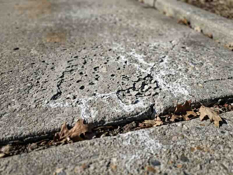 Close-up of concrete surface showing spalling and salt damage from Indiana winters