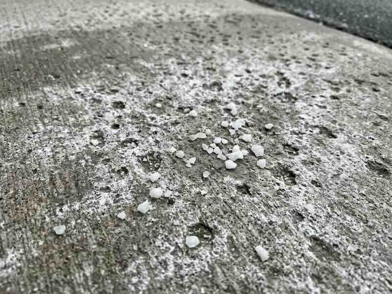 Close-up of concrete surface showing pitting and deterioration caused by road salt and deicing chemicals in Indianapolis