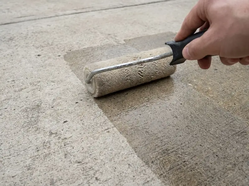 Penetrating sealer soaking into an Indianapolis concrete driveway to block road salt and chloride damage